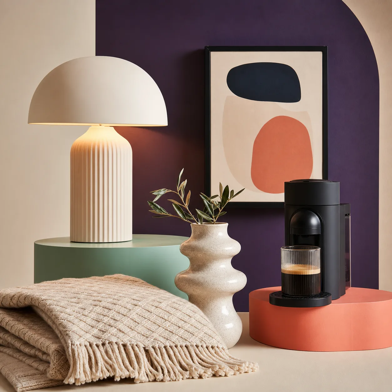 Collection maison avec lampe, cafetière, vase et jeté texturé.